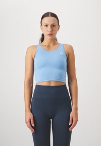 Top corto sportivo azzurro chiaro realizzato in tessuto elastico; leggings high-waisted a coste blu scuro, entrambi progettati per comfort e prestazioni.