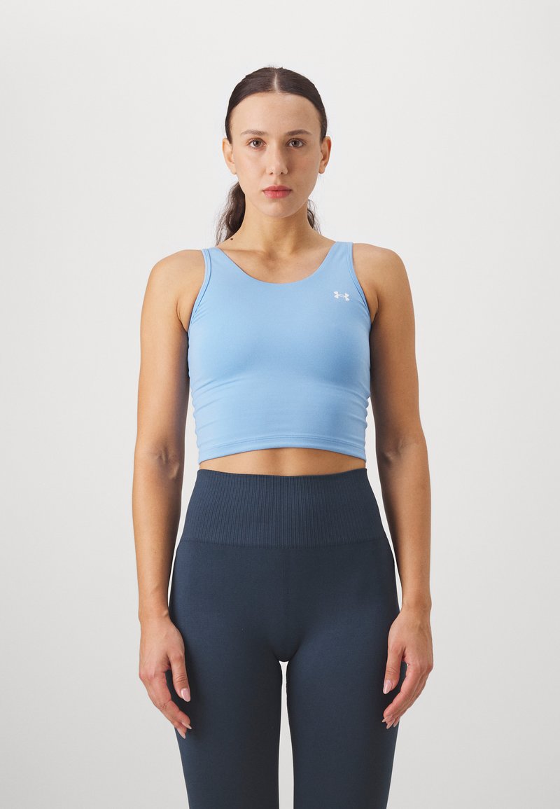 Top corto sportivo azzurro chiaro realizzato in tessuto elastico; leggings high-waisted a coste blu scuro, entrambi progettati per comfort e prestazioni.