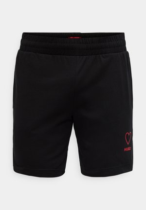 Shorts de sport noirs avec une taille élastique, ornés d'un logo cœur rouge et du texte "HUGO" sur le côté inférieur. Texture lisse.