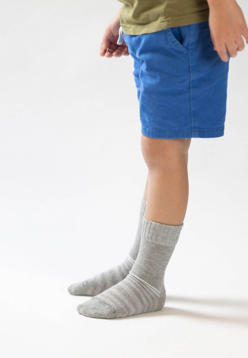 Blå bomuldsshorts med lommer, parret med strukturerede grå sokker med striber. Sokkerne har ribbet kant og en spids tådesign.