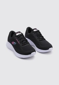 Scarpe sportive nere con tomaia in rete, suola maculata bianca e dettagli in rosa sul logo. Presentano un collo imbottito e un design con lacci per una vestibilità sicura.