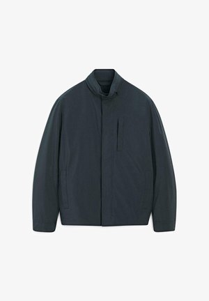 Veste bleu foncé avec col montant, poche zippée horizontale et deux poches latérales. Texture lisse, design minimaliste, sans motifs.