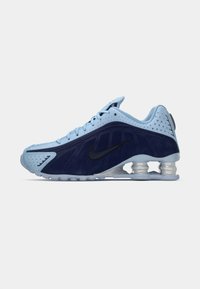 Hellblau und marineblaue Nike Sportschuhe mit schwarzem Swoosh, perforiertem Obermaterial, sichtbarer Luftpolstersohle und Schnürverschluss.