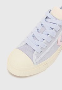 Jasnofioletowe zamszowe sneakersy z kremowym gumowym noskiem, pastelowym różowym logo i pasującymi sznurówkami. Posiadają teksturowaną boczną panelę oraz przeszycia.