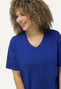 T-shirt blu a V realizzato in tessuto jersey con maniche corte, caratterizzato da una vestibilità morbida e una texture liscia.