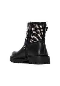 Des bottines en cuir noir avec une fermeture éclair sur le côté et des clous métalliques recouvrant le dessus pour ajouter texture et détail. Semelle en caoutchouc épaisse.
