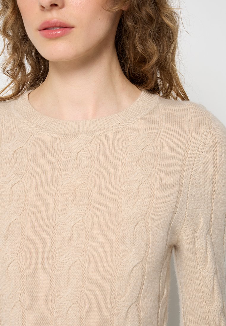 Hellbeige, grob gestrickter Pullover mit rundem Halsausschnitt. Weiche Textur und detailliertes Kabelmuster, mit gerippten Bündchen und Saum.