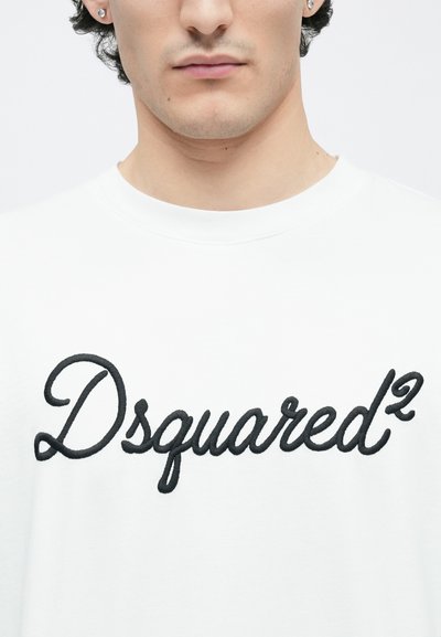 White cotton t-shirt featuring a prominent black embroidered "Dsquared²" logo on the front, round neckline, and short sleeves.