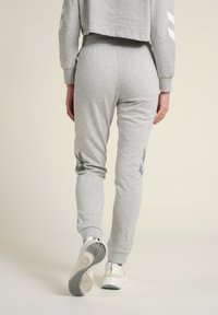 Grå sweatpants i mjukt material, med slim fit, elastisk midja och sidologotyper i mörkgrått.