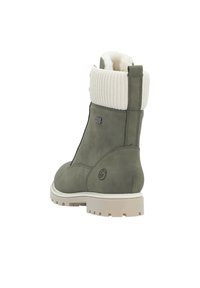 Botín gris-verde con un puño de punto blanco, textura suave, detalle de cremallera y suela resistente y duradera.