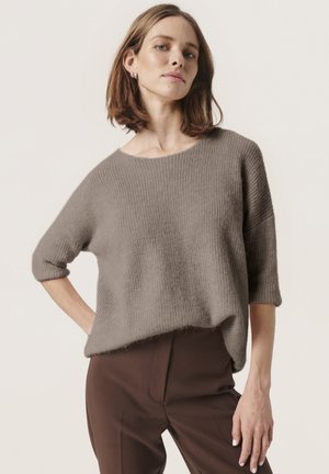 Grey knit sweater with a relaxed fit, wide neckline, and three-quarter sleeves, paired with brown tailored trousers. Soft texture, lightweight.