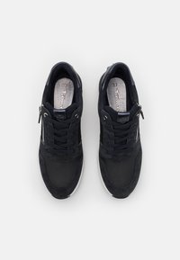 Black sneakers with a mix of suede and smooth material, featuring lace-up design and side zipper. Light-colored sole, textured details.