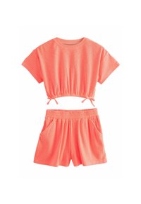 Completo due pezzi corallo con top corto dotato di arricciature elastiche e pantaloni shorts con tasche, realizzato in un tessuto morbido e leggero.