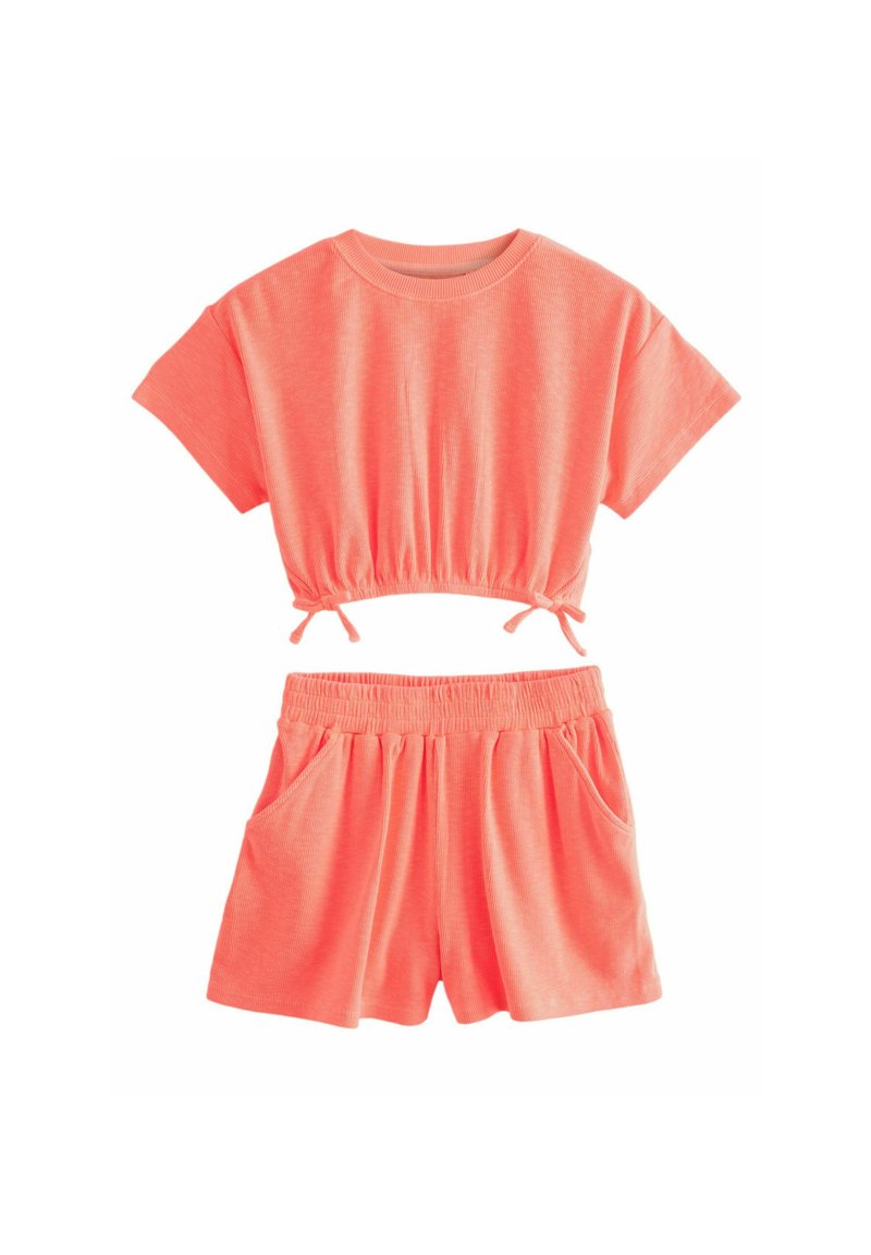 Completo due pezzi corallo con top corto dotato di arricciature elastiche e pantaloni shorts con tasche, realizzato in un tessuto morbido e leggero.