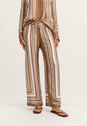 Brown and white vertical striped wide-leg pants with drawstring waist, paired with matching top and brown flat sandals.