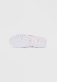 Λευκή σόλα αθλητικού παπουτσιού με υφή πρόσφυσης και ροζ λεπτομέρεια. Διαθέτει συνδυασμό λείας και υφασμάτινης επιφάνειας.