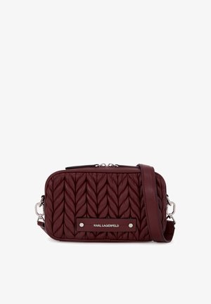 Βουργουνδί κομψή τσάντα χιαστί με ορθογώνιο σχήμα, κλείσιμο με φερμουάρ, ρυθμιζόμενο λουράκι και υπογραφή λογότυπο σε μαύρη μπάντα.