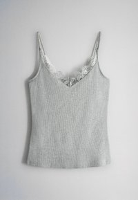 Svetlosivý pletený bezrukávový top s tenkými ramienkami a bielou čipkovou výzdobou pozdĺž V-čkového výstrihu na neutrálom pozadí.