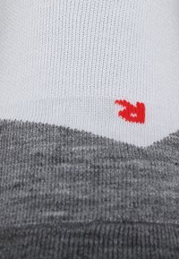 Grau-weiße Socke mit strukturiertem Design; verfügt über ein kleines, leuchtend rotes Logo; geripptes Oberteil und glattes Gewebe am Körper.
