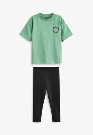 Camiseta verde de manga corta con texto negro que dice "Cool Kid All Day" y leggins negros, fabricados en una suave mezcla de algodón elástico.