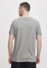 Grå t-skjorte med korte ermer laget av myk bomullsblanding, med rund hals og avslappet passform. Minimalistisk design uten synlige mønstre eller detaljer.