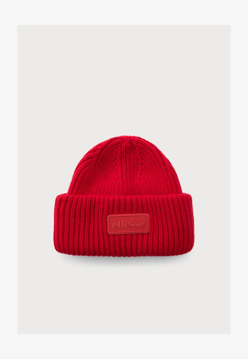 Rød strikket lue med brett som har et rektangulært merke merket "ellesse" på en ensfarget bakgrunn.