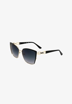 Occhiali da sole cat-eye neri e oro con lenti sfumate scure e dettagli a catena sulle aste, marchiati "Guess" su entrambi i lati.