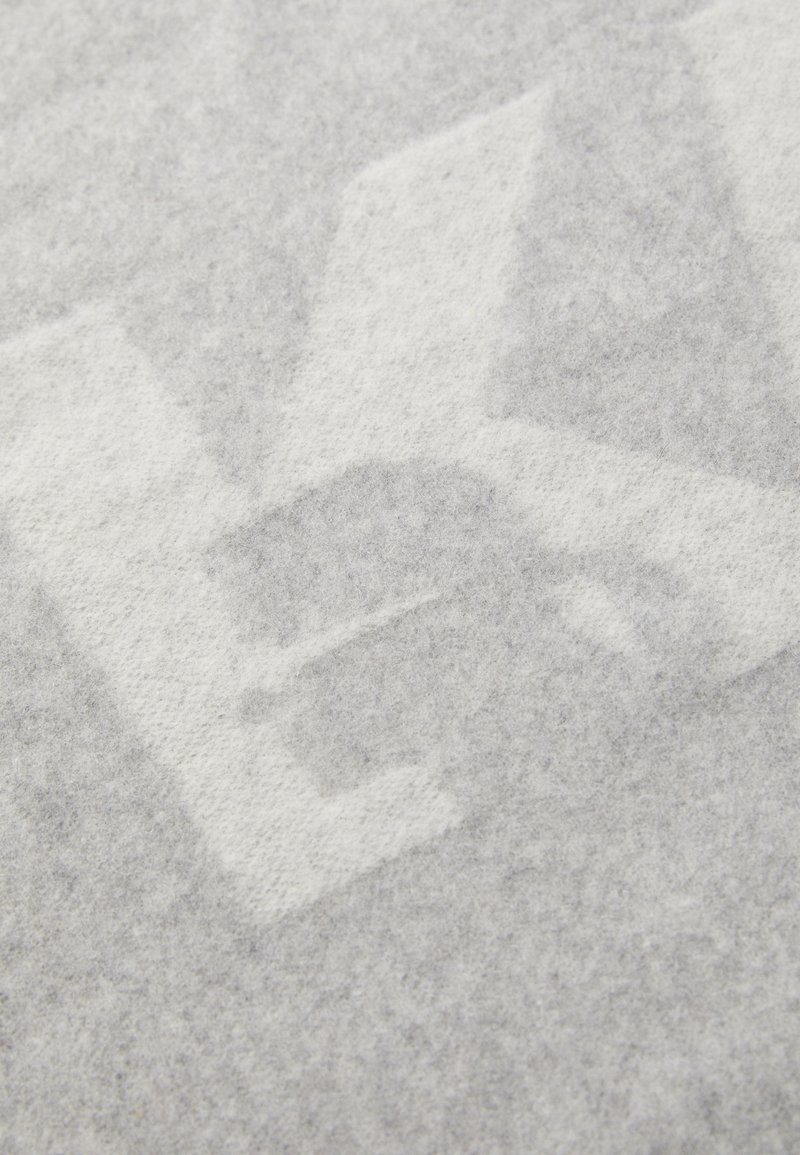 Tissu en feutre gris avec une texture douce, présentant un motif abstrait subtil dans une teinte plus claire, créant une apparence superposée.