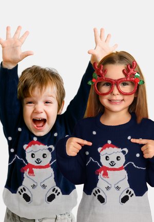 Maglione blu con un design di un orso polare, dotato di sciarpa e cappello rossi. Decorato con fiocchi di neve bianchi su uno sfondo scuro. Tessuto a maglia texturizzato.