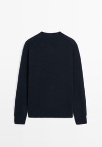 Maglione a coste di un blu navy, con scollo rotondo, maniche lunghe e sottili spacchi laterali nell'orlo per un maggiore comfort e vestibilità.