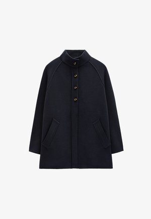 Granatowy wełniany płaszcz z wysokim kołnierzem, pięcioma złotymi guzikami i dwiema przednimi kieszeniami. Posiada rękawy raglanowe oraz luźny krój.