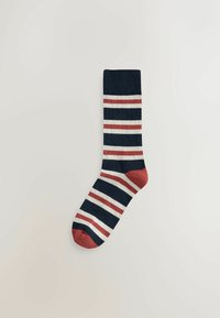 Gestreifte Socke mit blauen, weißen und roten Streifen, einem roten Bündchen und Zeh. Hergestellt aus einem weichen, strukturierten Stoff für Komfort.