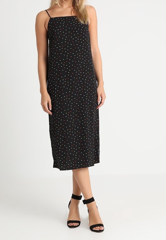 Svart midiklänning med spaghetti-band och prickigt mönster i rött, vitt och teal. Tyget verkar lätt och klänningen har en avslappnad passform.