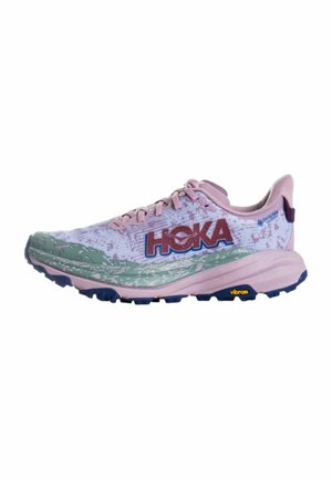 Zapatilla de running HOKA de color morado claro y rosa con detalles verdes, suela Vibram y diseño con cordones, vista de lado sobre fondo blanco.