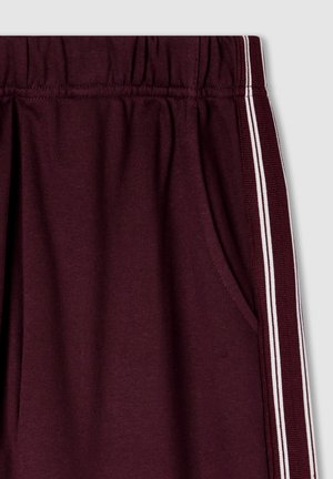 Pantaloni della tuta bordeaux con vita elastica, tasche laterali e accenti a strisce bianche lungo le cuciture esterne. Tessuto morbido.