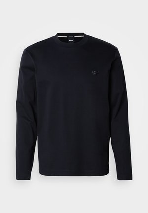 Tamsiai mėlynas ilgomis rankovėmis medvilninis marškinėlis su apvalia apykakle ir mažyte išsiuvinėta krūtinės logotipu, pasižymintis lygiu paviršiumi ir įprastu prigludimu.