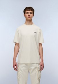 Μπεζ βαμβακερό μπλουζάκι με στρογγυλή λαιμόκοψη και κοντά μανίκια. Διαθέτει μικρό γραφικό στην περιοχή του στήθους, με άνετη εφαρμογή.