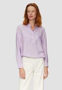 Lichtpaarse lange mouwen shirt met een knoopsluiting, twee borstzakken en een gestructureerde stof, gecombineerd met witte broek.