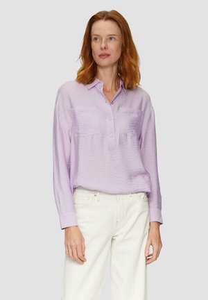 Chemise à manches longues violet clair avec patte de boutonnage, deux poches poitrine et tissu texturé, assortie à un pantalon blanc.