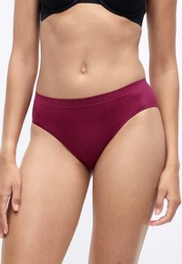 Burgundské boxerky Calvin Klein s hladkým povrchom, širokým pásom so vystúpeným logom, klasickým strihom hipster a dizajnom s minimálnym krytím.
