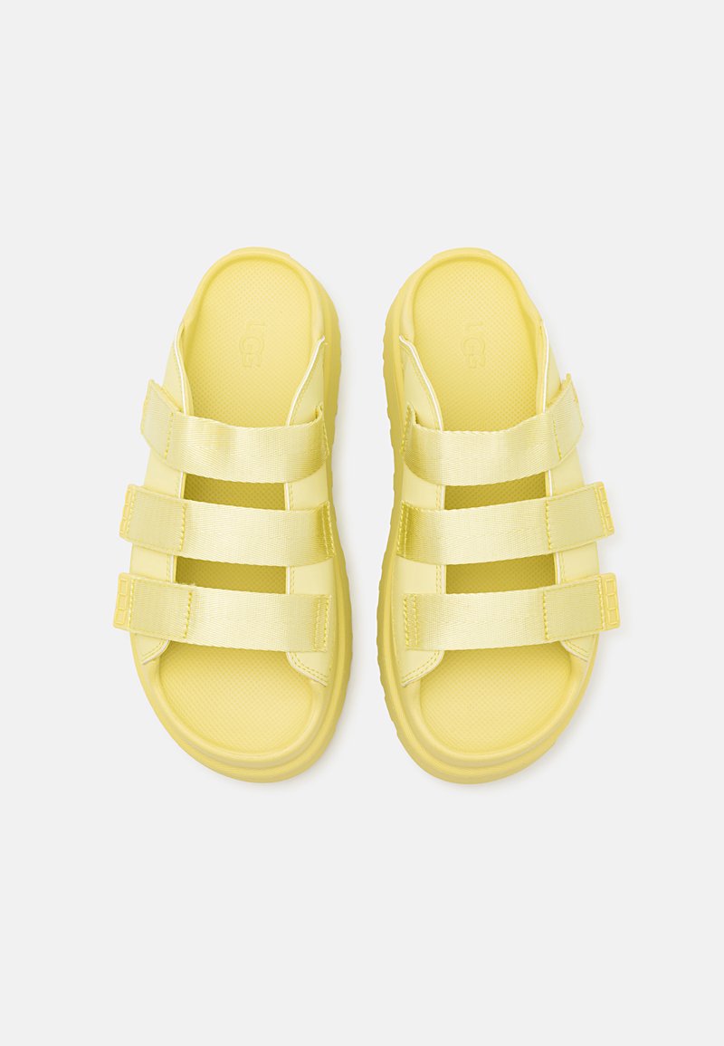 Sandali gialli con tre cinturini in satin regolabili. Realizzati in materiale simile alla gomma, con suola testurizzata e design open toe.