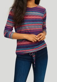 Top a maniche lunghe lavorato a maglia multicolore, presenta un motivo a zigzag in sfumature di viola, blu e rosa, con scollatura rotonda e orlo con cordino.