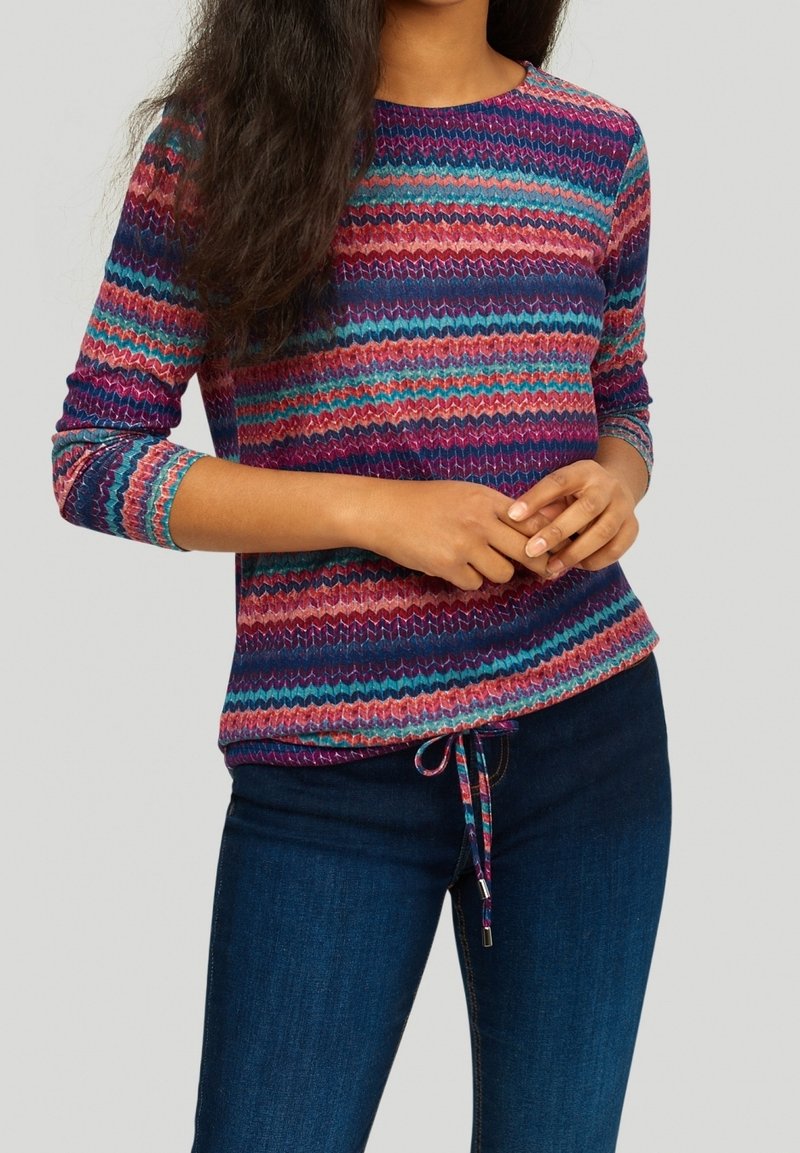 Top a maniche lunghe lavorato a maglia multicolore, presenta un motivo a zigzag in sfumature di viola, blu e rosa, con scollatura rotonda e orlo con cordino.
