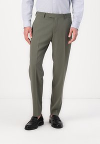 Olivgröna byxor i slät tyg, med skräddarsydd passform, pressveck fram och bälteshällor, ihop med svarta läderslip-in skor.