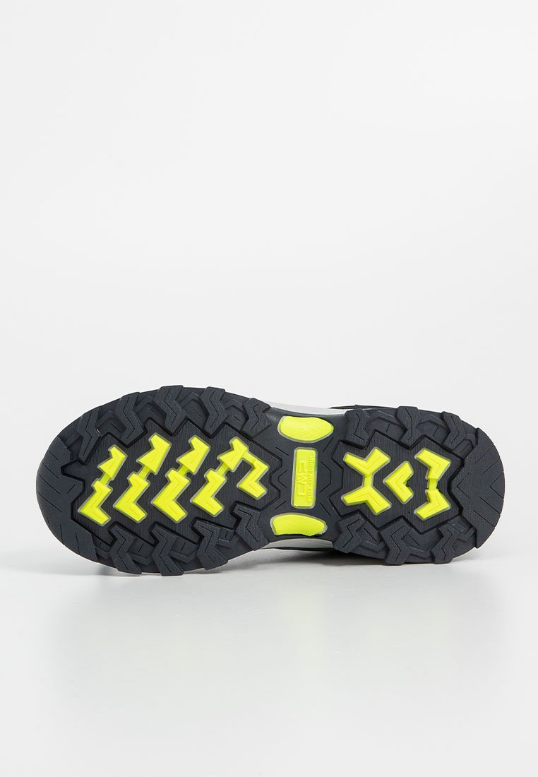 Semelle de chaussure de trail running présentant une base en caoutchouc noir texturé avec un motif en zigzag distinctif et des accents de traction jaune vif.