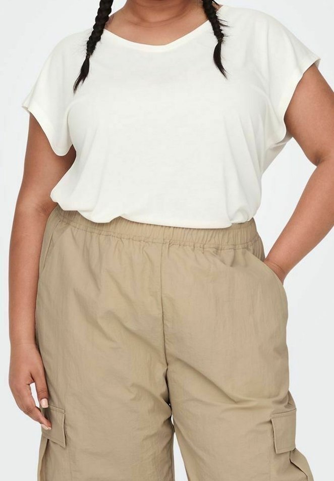 T-shirt crema a maniche corte con vestibilità ampia abbinato a pantaloni cargo beige con tasche laterali e cintura elastica.