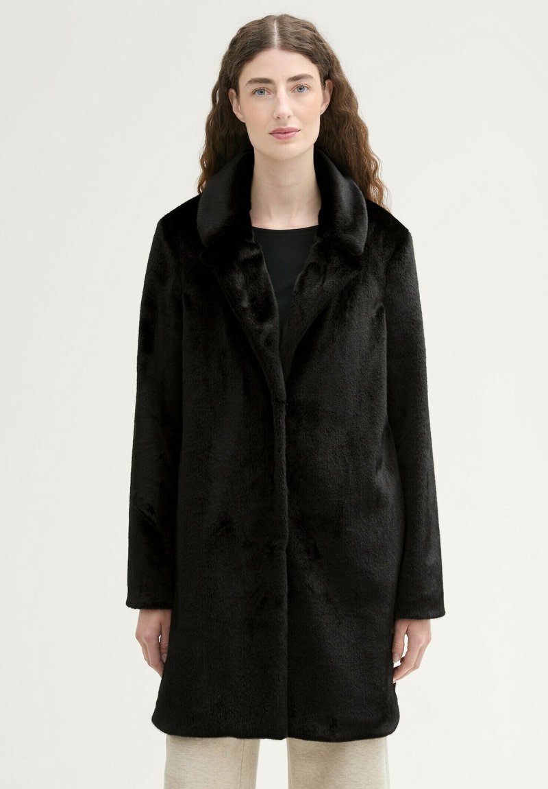 Cappotto in pelliccia sintetica nera con un ampio colletto, maniche lunghe e una silhouette dritta. Texture morbida, design minimalista e senza chiusure visibili.