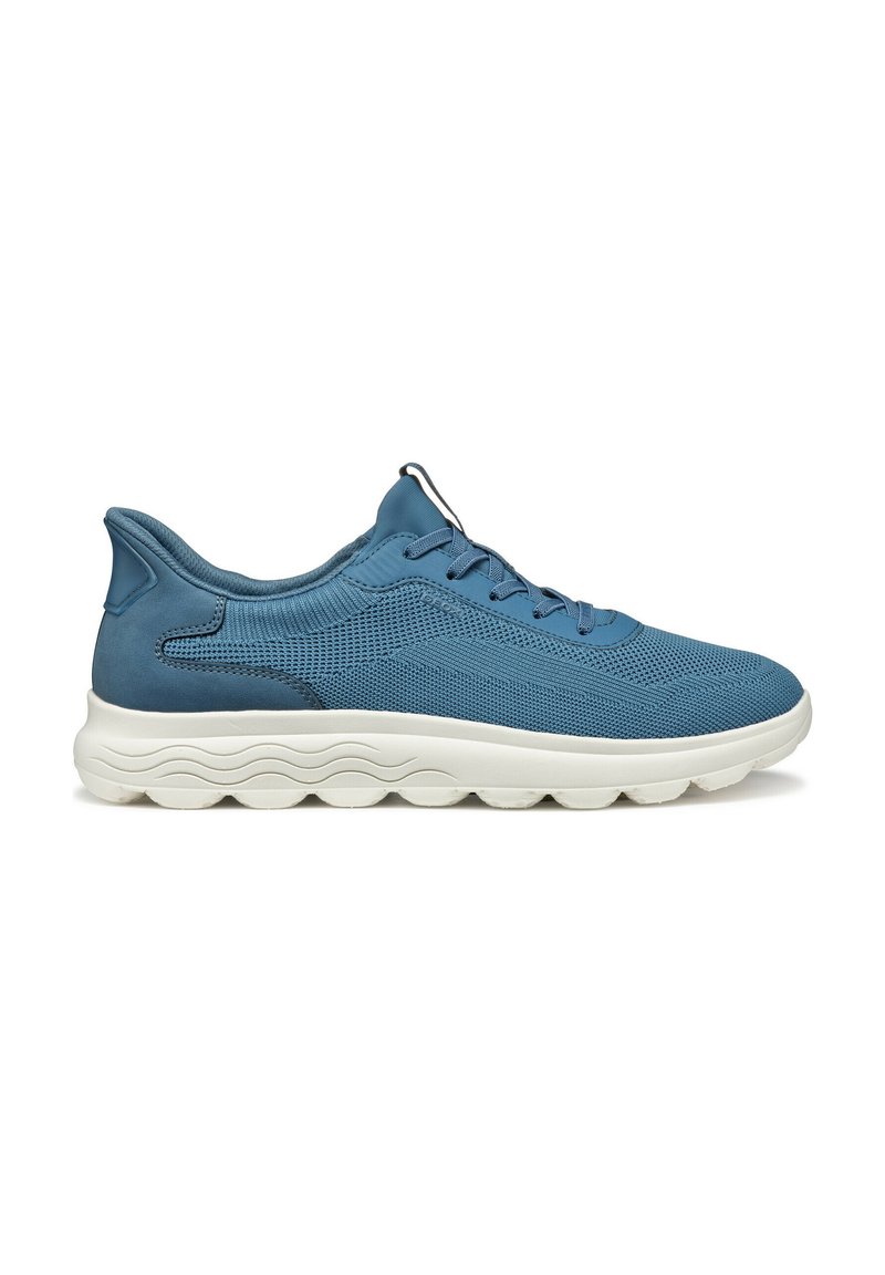 Scarpe da ginnastica blu con una tomaia in rete intrecciata e dettagli lisci. Suola imbottita di colore chiaro con un design a onda per una presa migliore.