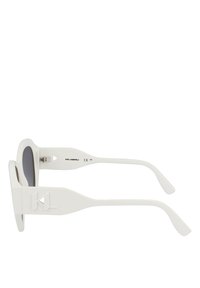 Lunettes de soleil blanches avec une monture carrée, des verres gris et des branches texturées comportant un logo. Design léger avec des courbes élégantes.