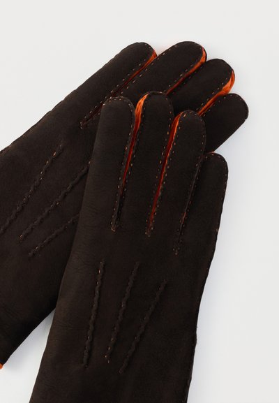 Barna bőrkesztyű narancssárga béléssel. Díszítő varrással és öt ujjjal rendelkezik. Simogató tapintású, puha és rugalmas kialakítású.